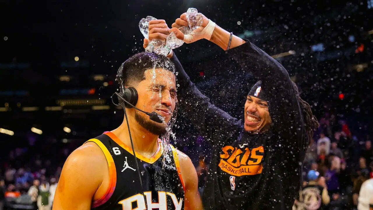 Dec 17, 2022; Phoenix, Arizona, USA; Phoenix Suns guard Devin Booker has water dumped on him by teammate Damion Lee after defeating the New Orleans Pelicans at Footprint Center. Mandatory Credit: Mark J. Rebilas-USA TODAY Sports